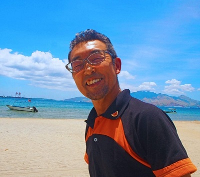 フィリピンの砂浜で笑顔を見せる中沢さん=本人提供