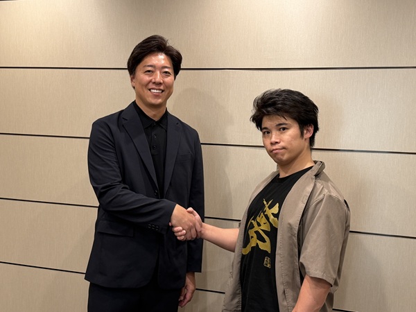 握手をする小林代表と成田童夢氏